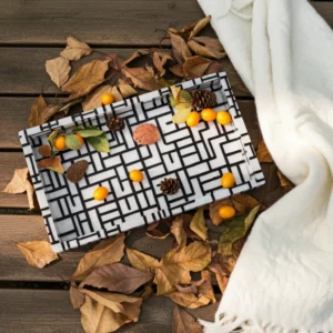 Bone inlay serving tray with black and white interlocking maze pattern placed on a marble table