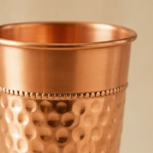 Handcrafted hammered copper cup featuring textured surface and smooth beaded detailing