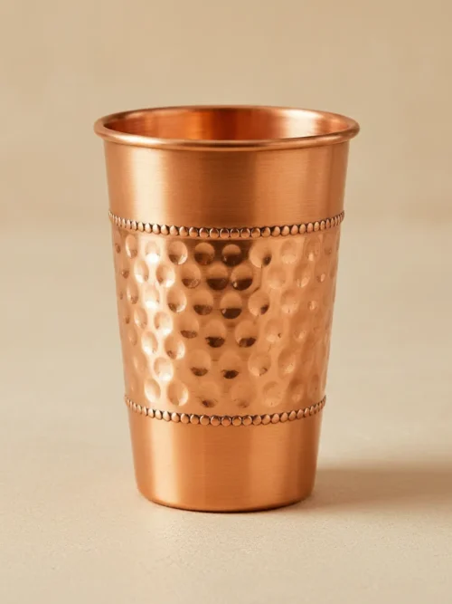 Decorative hammered copper cup with embossed texture and artisan beaded bands